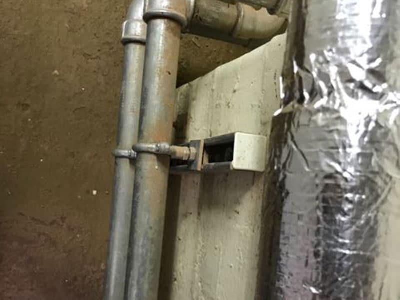Asbestos insulation debris and snots stuck to the surfaces of pipework or vessels below modern insulation. Usually due to historic asbestos removal operations.