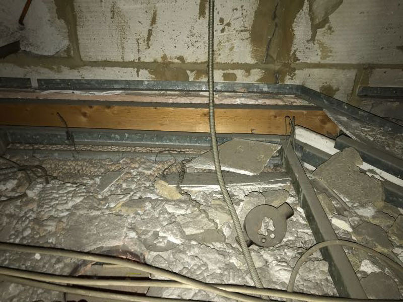 Asbestos insulating board debris laying on ceilings and tiles within ceiling voids. Usually from previous damage or previous asbestos removal operations.
